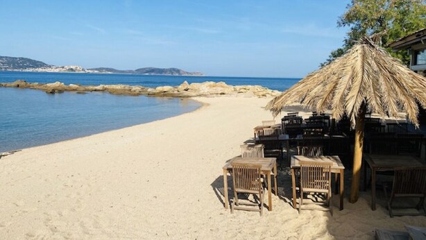 A beachside restaurant with outdoor seating and a thatched roof. - A little gem in lush greenery - sea view (lumio)