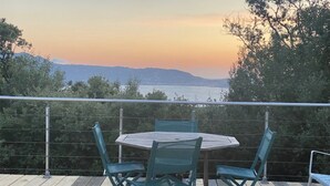 A round table with four chairs on a deck with a view of the sea and mountains. - A little gem in lush greenery - sea view (lumio)