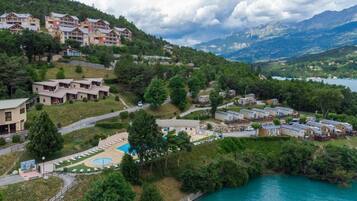 Un resort con varias construcciones, una piscina y un lago.