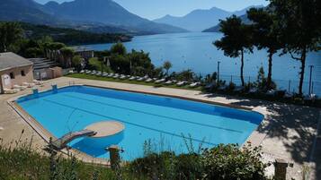 Una piscina con vistas a montañas y un lago.