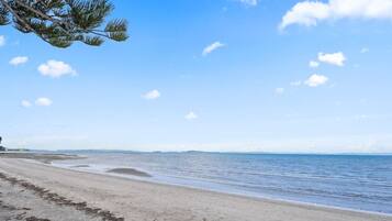 Enjoy a serene beach experience with a gentle slope leading to the calm sea.