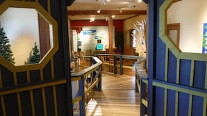 Un interior de madera con una escalera que lleva a una habitación con una computadora y un letrero que dice "¿Vives en una casa árbol?"