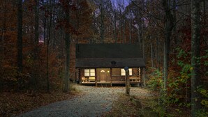 A rustic cabin with a porch, surrounded by a forest. - Cabin In Hocking Hills! Pet Friendly, Hot Tub, Secluded. (Logan)