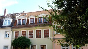 Une rangée de maisons à deux étages bordant une rue pavée.