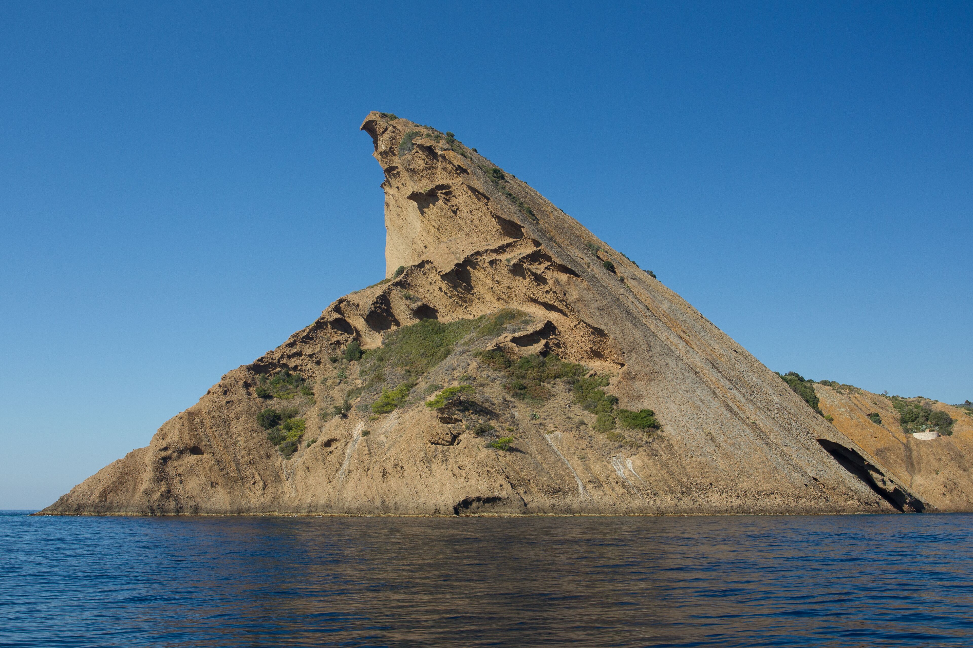 A large, rocky island with a steep cliff and sparse vegetation.