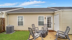 Einbungalow mit einer Veranda, auf der sich ein Tisch und vier Stühle befinden.
