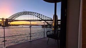 Un balcón con vista a un puente sobre el agua durante el atardecer.