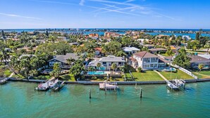A coastal residential area with houses, a marina, and a clear view of the ocean.