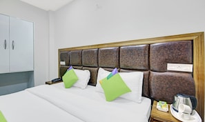 A hotel room with a bed, a nightstand, a wardrobe, and a headboard. - Hotel Royal Salute (Dera Bassi)