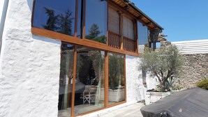 A modern building with large glass windows, a stone exterior, and a wooden balcony.