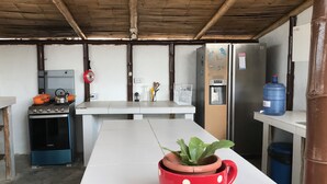 A kitchen with a stove, oven, refrigerator, and a water dispenser.