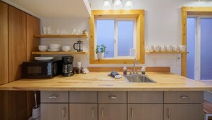 Una cocina con gabinetes de madera, una encimera, un fregadero, una cafetera y una ventana con vistas.