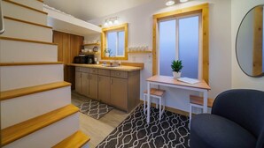 Una cocina compacta con armarios de madera, una encimera y una zona de comedor con mesa y silla.