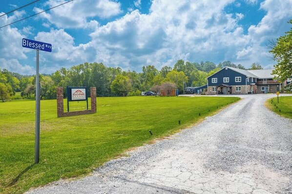 A gravel driveway leading to a building with a sign reading "Blessed Way". - Suite 112: Comfort at Rock Spring Resort (Rock Spring)