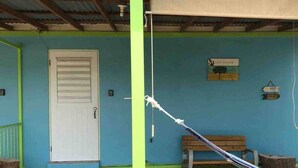 A building with a blue exterior, a white door, and a bench. - Cayo Enrique at Guayacán Guest House (Lajas)