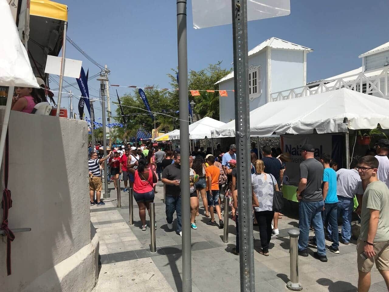 A crowded outdoor event with people walking and standing around.