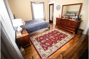 Cozy retreat with a large bed, dresser, and reading nook.