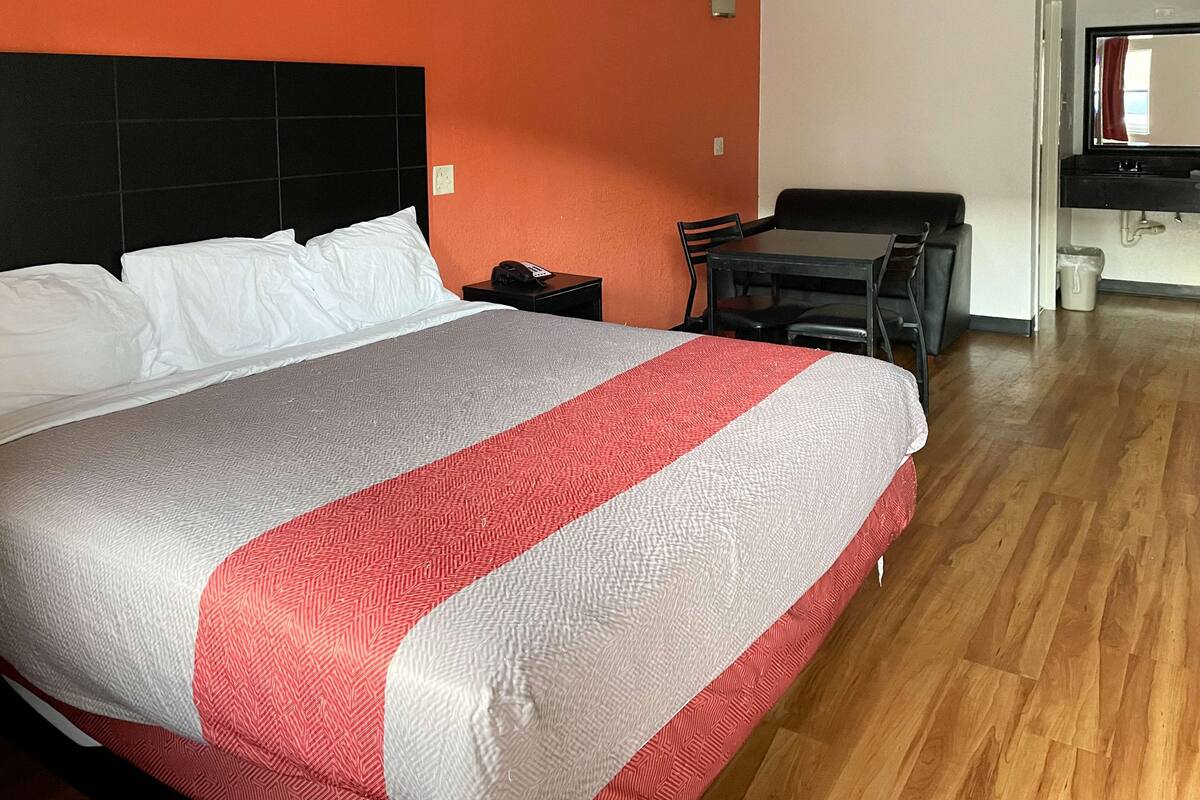 A hotel room with a bed, a desk, and a chair.
