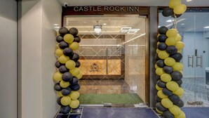 De ingang van Castle Rock Inn met een modern ontwerp, met een glazen deur en een logo op de deur.