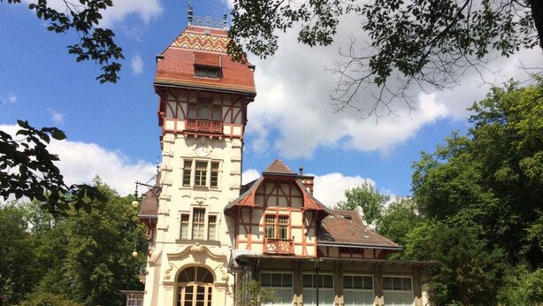 Een historisch gebouw met een opvallende toren en een traditionele gevel.