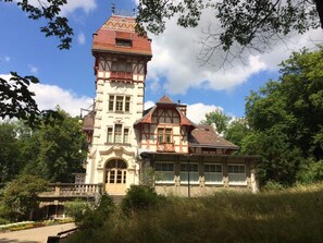 Een historisch gebouw met een opvallende toren en een traditionele gevel.