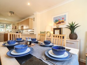 A dining area with a table set for six, featuring blue bowls and plates.