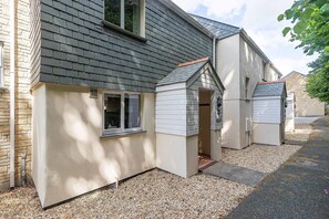 A house with a sloped roof, a small attached garage, and a gravel driveway.