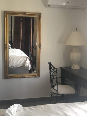 A bedroom with a large mirror, a bed, a chair, and a lamp. - Immaculate 1-bed Apartment on Ocean View (Philipsburg)