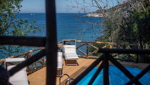 A poolside area with lounge chairs and a wooden deck overlooking the sea. - Villa Ad Maiora in Massa Lubrense (Massa Lubrense)