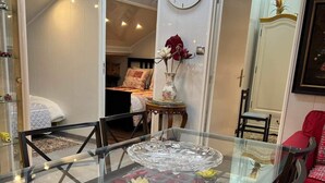 A dining area with a glass-top table, red cushioned chairs, and a world map on the wall. - Apartment T LUXE (Pierrefitte-sur-Seine)