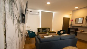 Un salon moderne avec un canapé, une table basse et un téléviseur fixé au mur.