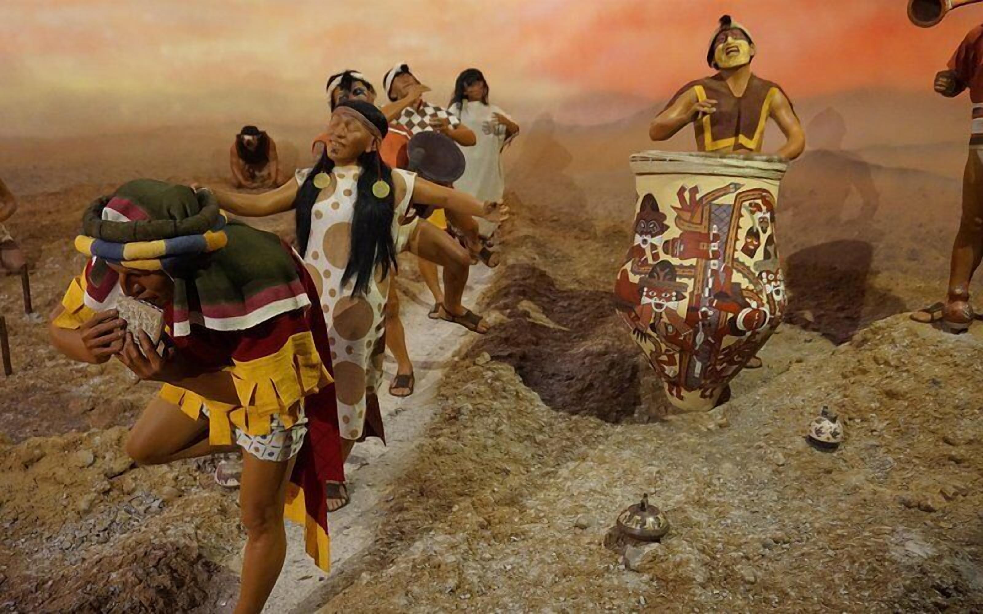 A museum exhibit with a large, colorful ceramic pot and several figures in traditional attire.