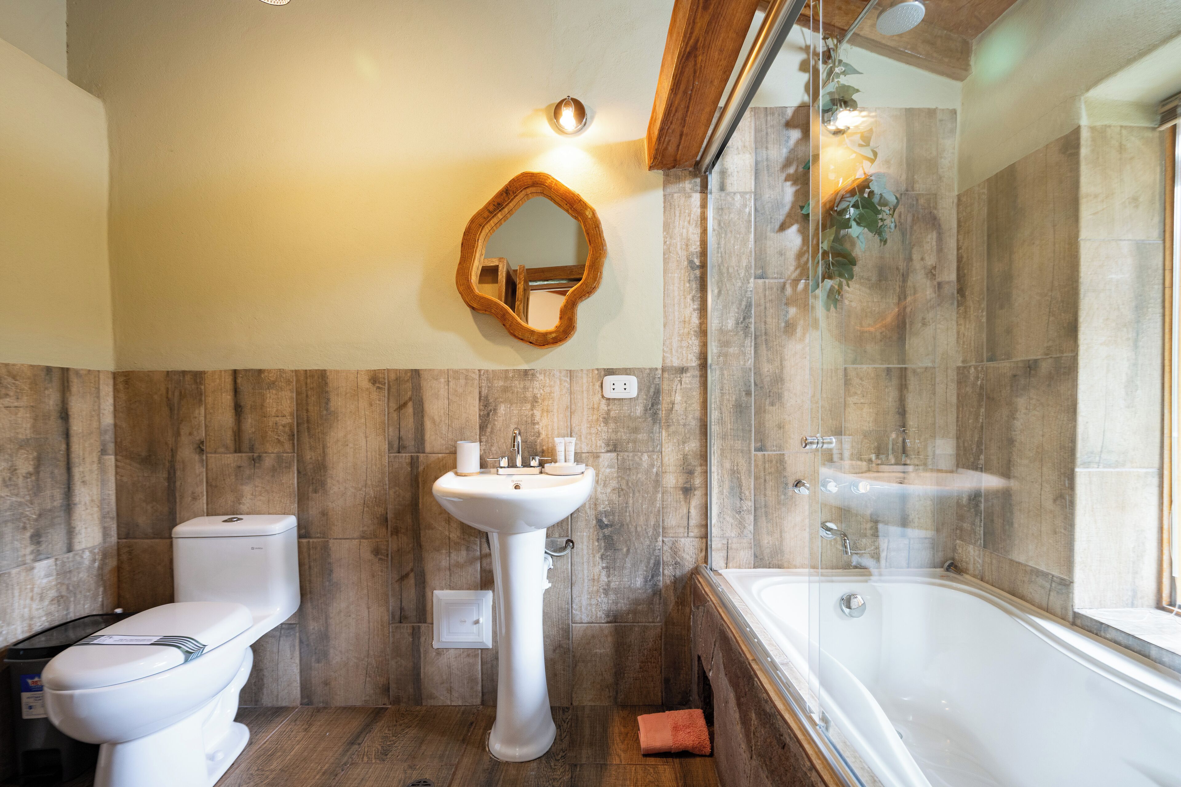 Et badeværelse med toilet, vask og badekar.