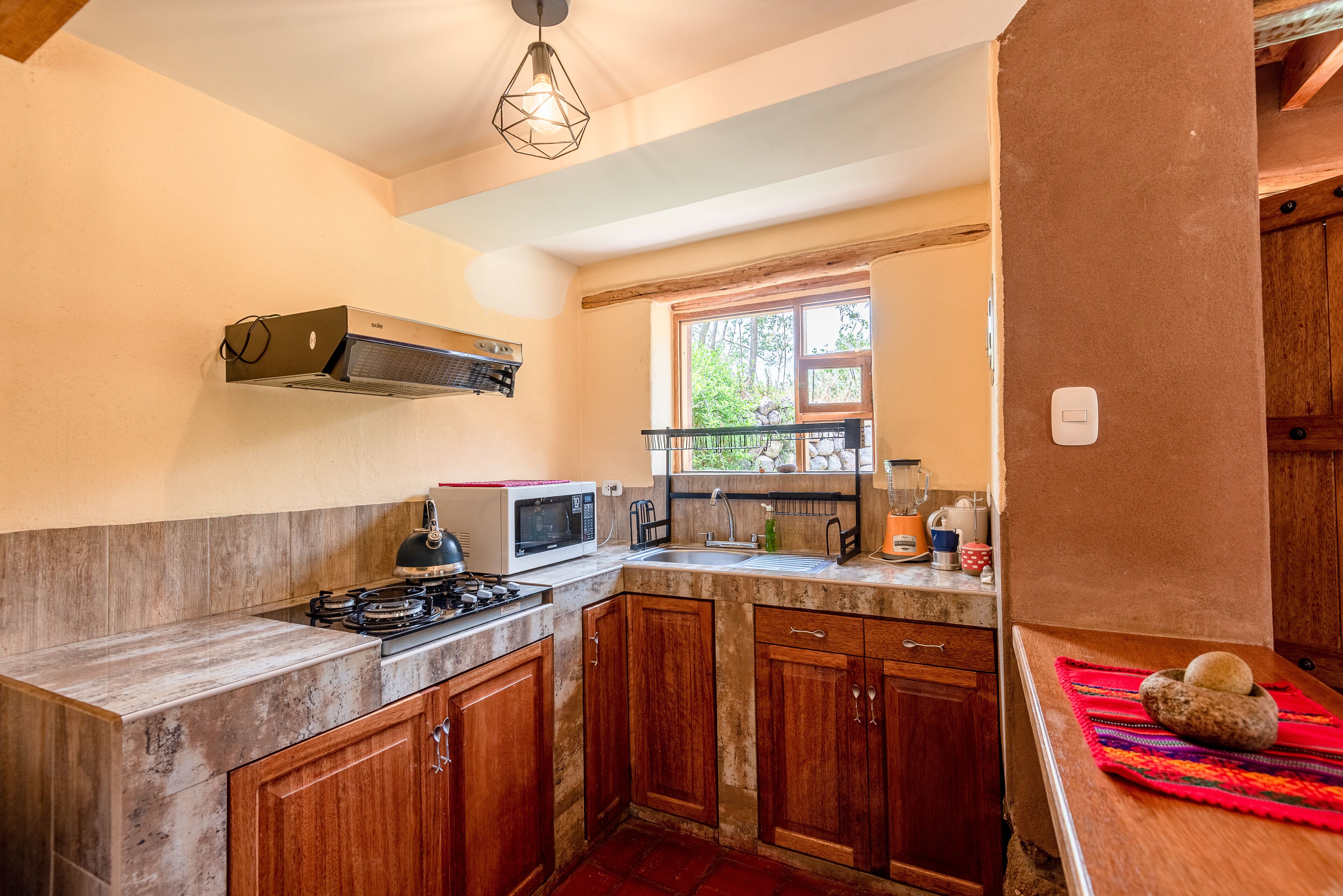 A compact kitchen with a gas stove, microwave, and wooden cabinets.