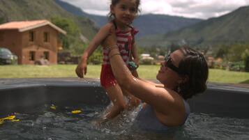 Guests can enjoy a refreshing swim in the pool surrounded by lush greenery and breathtaking mountain views.