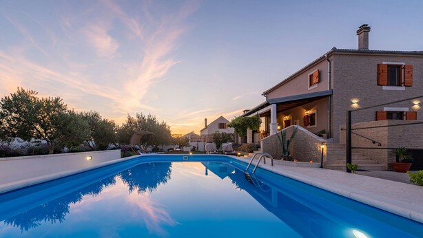 Piscina con vista despejada de los edificios circundantes y un cielo al atardecer.