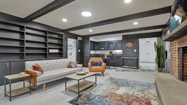 A modern living room with a sofa, armchair, coffee table, and a large abstract rug. - Spacious, Modern, Healing Home in Columbus (Columbus)
