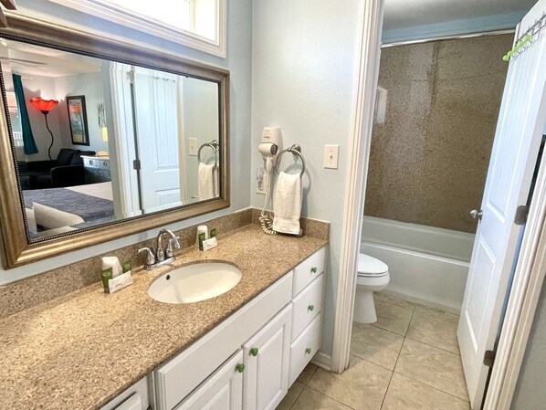 A bathroom with a sink, mirror, towel rack, and toilet.