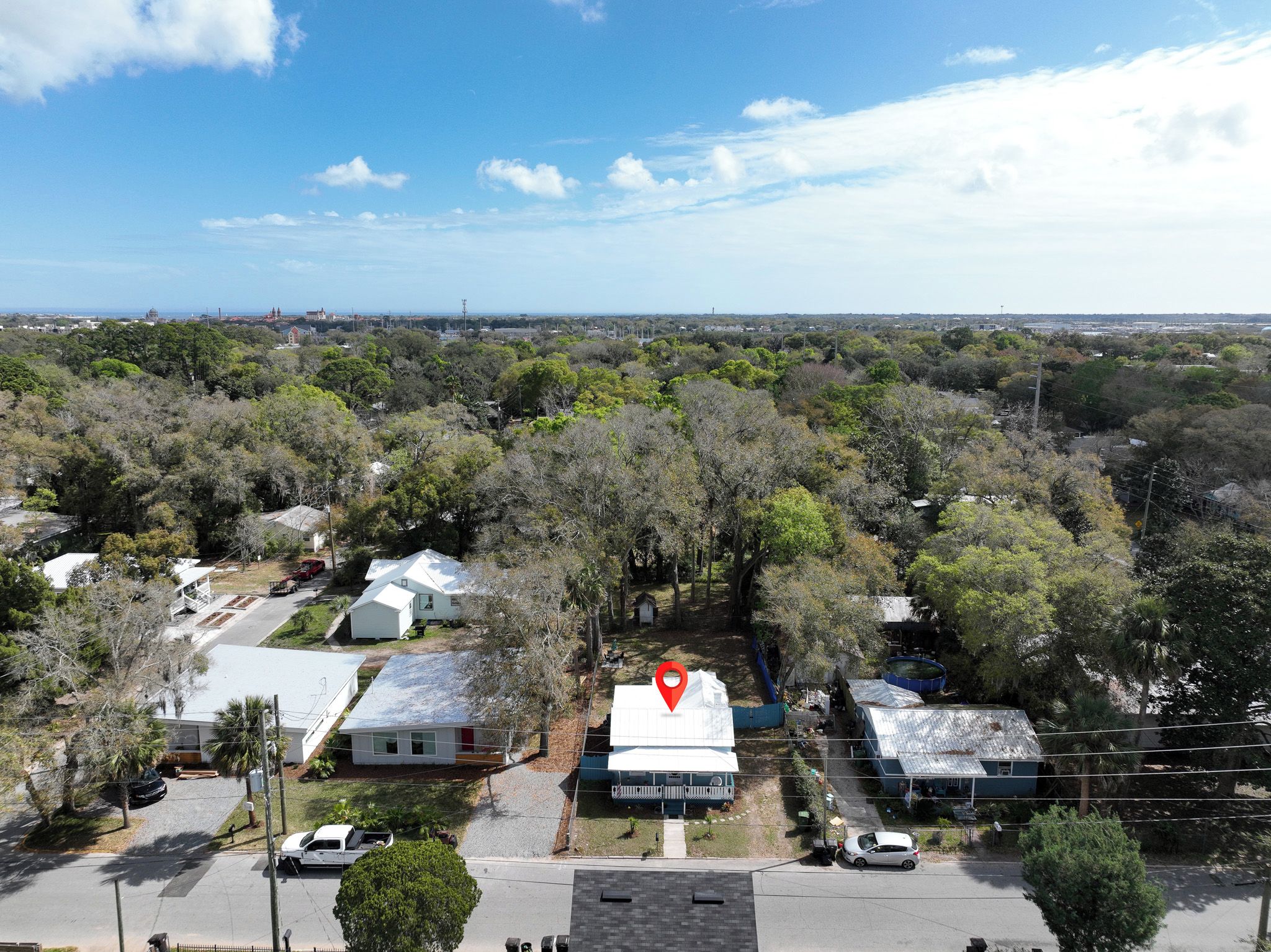 A residential area with houses, trees, and a clear sky.