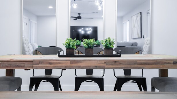 Una sala conferenze moderna con un tavolo in legno, quattro sedie e piante in vaso.