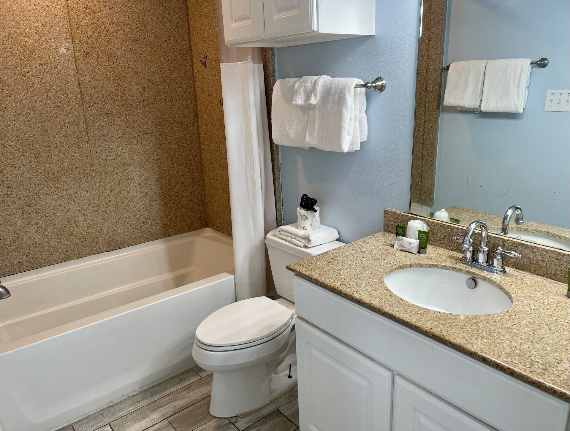 A bathroom with a bathtub, toilet, sink, and a mirror.