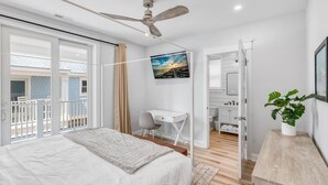 A modern bedroom with a large bed, a desk, and a balcony. - BRAND NEW OCEANFRONT 3 Bedroom 2 bath 1st floor villa (Honu) (Cape May)