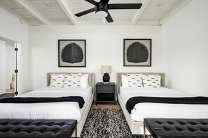 A hotel room with two beds, a ceiling fan, a nightstand with a lamp, and artwork on the walls. - Exciting backyard entertainment and close to exclusive golf courses at La Quinta Del Sol (Scottsdale)