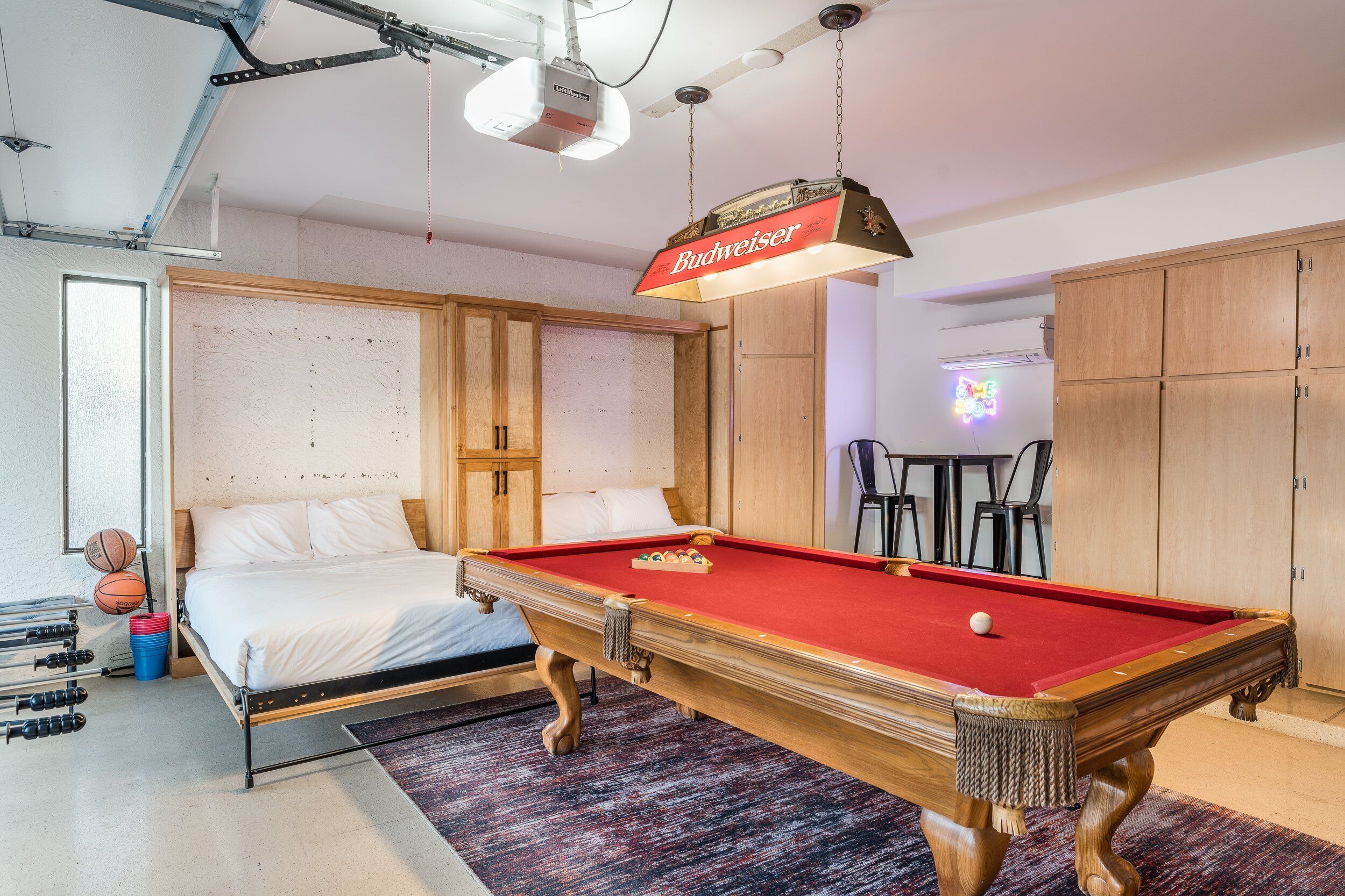 A hotel room with a pool table, bed, and a projector screen in the background.