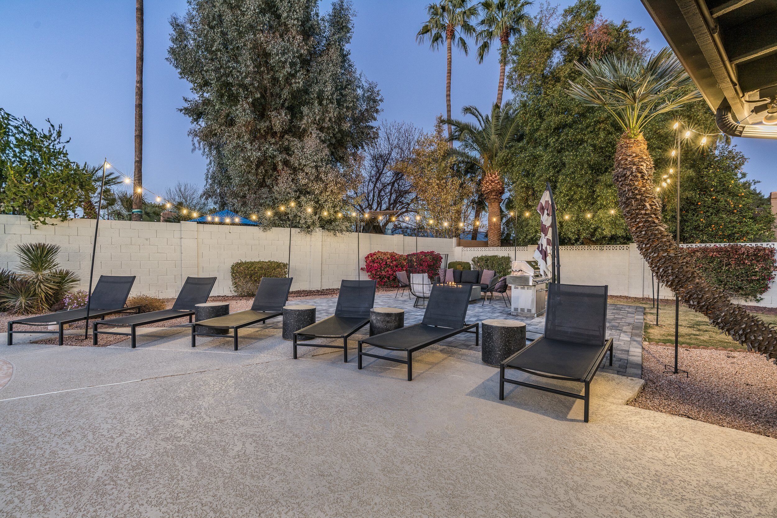 An outdoor seating area with lounge chairs and a decorative string of lights.