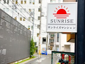 A sign for Sunrise, a hotel with a modern design and a view of the street.
