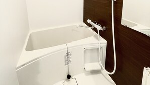 Un baño moderno con bañera, ducha y espejo.