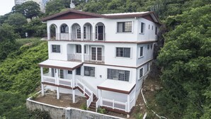 Un immeuble de deux étages doté d’un balcon et d’un escalier.