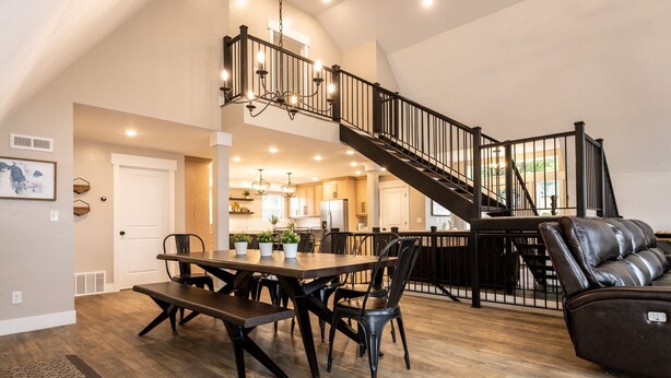 A spacious living area with a dining table, chairs, a leather sofa, and a staircase leading to an upper level. - The spacious “LavaBarn” in Lava Hot Springs (Lava Hot Springs)