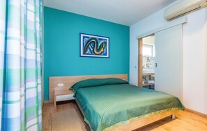 Cozy retreat with a comfortable bed, framed artwork, and a bathroom just steps away.